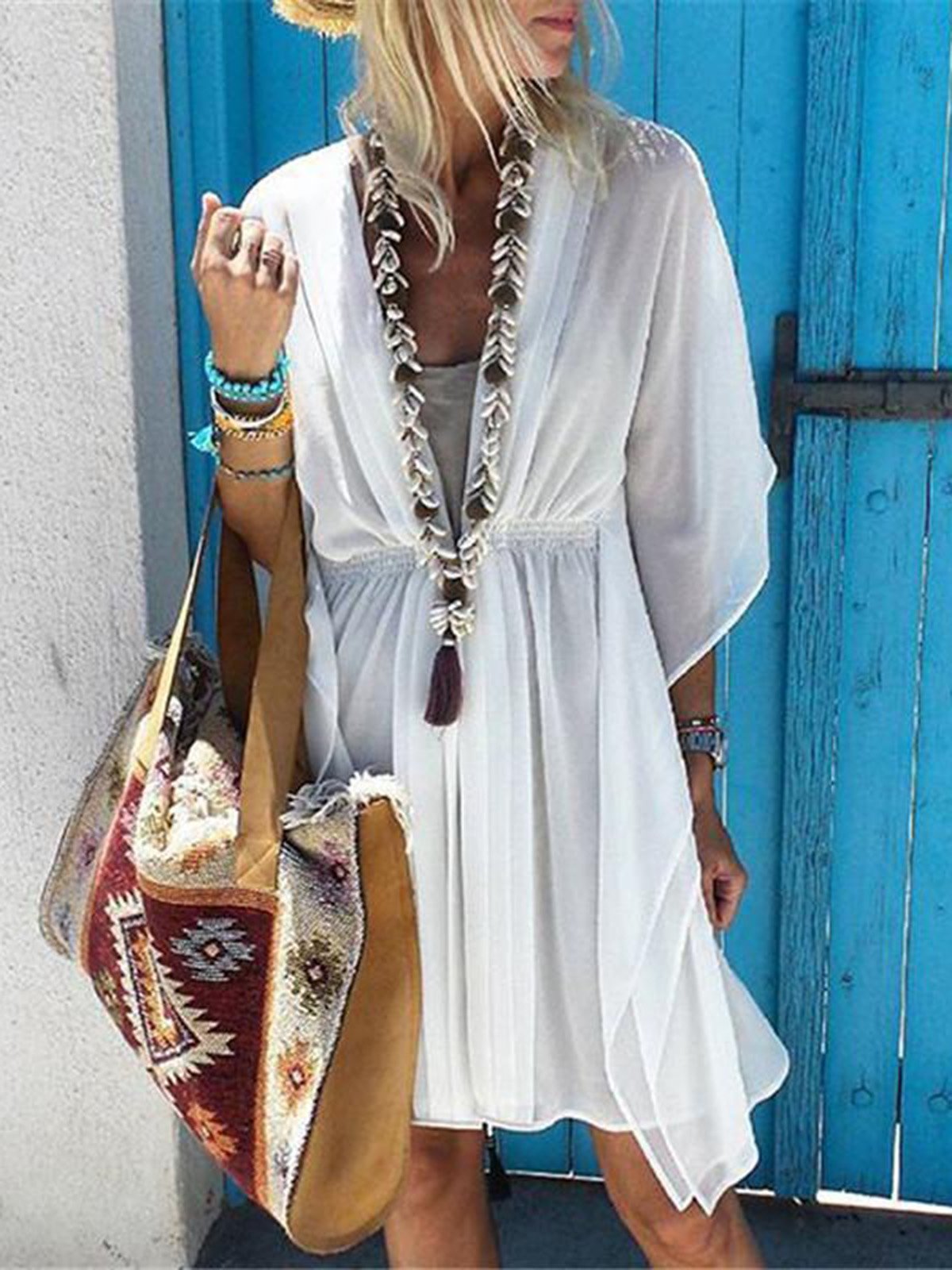 Dameszomerjurk met asymmetrische snit voor op het strand