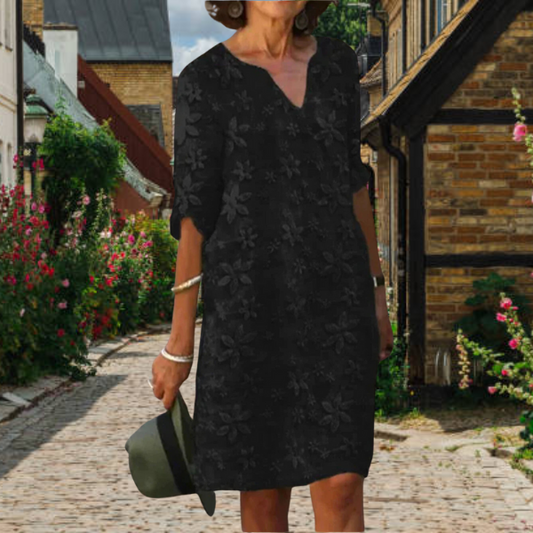 Elegante jurk tot op de knieën met driekwart mouwen en een subtiel bloemenprint.